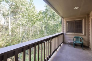 Enjoy the private patio with forest views in the summer at the Snow Flower 149 vacation rental.