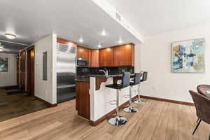 The modern kitchen features stainless steel appliances and a convenient breakfast bar with seating for 3 guests.
