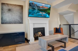 The cozy living room with large flatscreen TV and gas burning fireplace.
