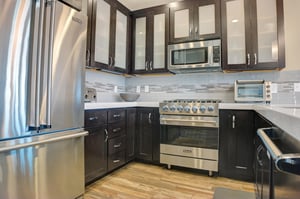 The kitchen with stainless steel Viking appliances, dark wood cabinets and neutral tiled backsplash.