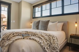 Main suite king bed with crisp white bedding, cozy pillows and blanket.