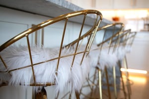 Sink into these luxurious gold chairs at the kitchen island with fluffy white cushions, where glamour meets comfort.