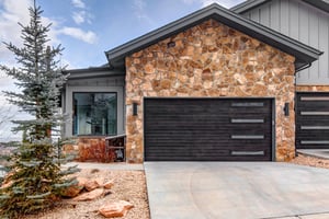 Modern mountain retreat featuring natural stone accents and and two car garage.