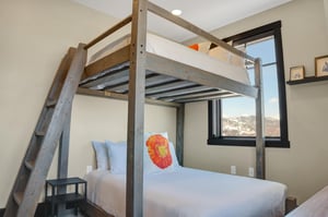 The third bedroom offers full size bunk beds and large windows with mountain views.