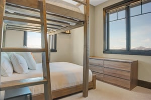 The bunk room with large windows and well appointed wood furniture.