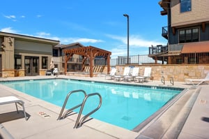 Blackstone 3823 vacation rental offers a common area pool and hot tub with many lounge chairs.