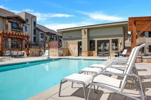 Stay at your private vacation rental with a common area swimming pool and lounge seating lining the sides at Canyons Village.