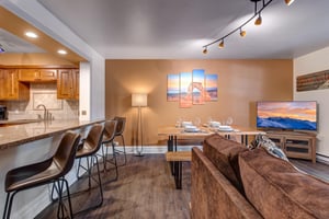 Relax in your stylish openconcept living space with modern kitchen, dining table for six, and comfortable seating area.