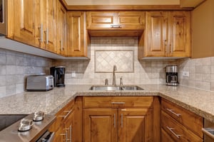 Your fully equipped kitchen features warm wood cabinetry, granite countertops, and modern appliances.