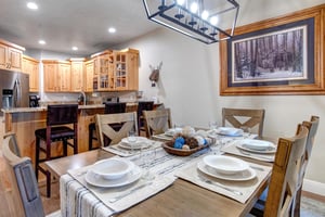 Gather around this inviting dining table where your group can share meals and stories, with a fully equipped kitchen ready for your culinary adventures and warm mountaininspired décor setting the per