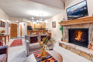 Gather around the crackling fireplace in this spacious openplan living area, where vaulted ceilings and mountain views on the TV create a cozy yet grand retreat for your group.