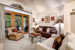 Sink into comfortable seating in your private living room, where natural light pours through sliding doors that open to your balcony. Warm leather, cozy armchairs, and thoughtful touches create your p