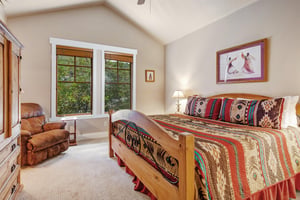Your cozy bedroom features vaulted ceilings, a comfy chair by the window, and colorful southwestern bedding that invites you to sink in and unwind after your adventures.