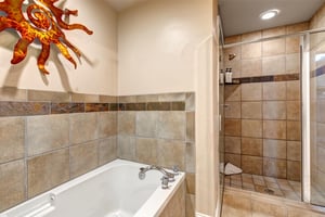 Soak in your deep tub or rinse off under the walkin shower—this earthytoned bathroom offers a serene retreat after mountain adventures, complete with playful sun décor overhead.
