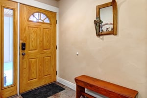 Step inside to a warm entryway with rustic charm. A welcoming bench offers you a spot to settle in, while thoughtful touches like a decorative mirror set the tone for your mountain retreat.