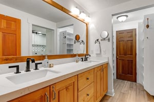 The en suite bathroom has two sinks and spacious vanity.