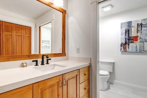 Your private bathroom features warm wood cabinetry and separate water closet.