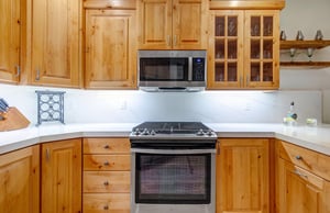 Cook up your favorite meals in this fullyequipped kitchen featuring warm wood cabinetry and plenty of counter space.
