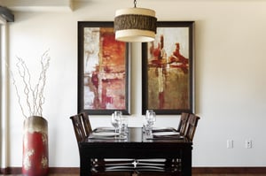 Cherry wood dining room table and high back wooden chairs, abstract modern art and oversized decorative floor vase
