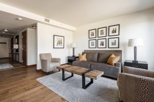 Hardwood floors throughout and large area rug in the living room, love seat sofa sleeper and accent chairs