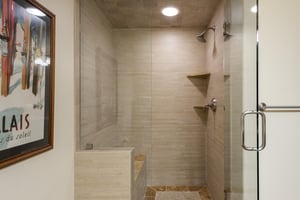 Shower in the guest bathroom with sandstone tiled walls