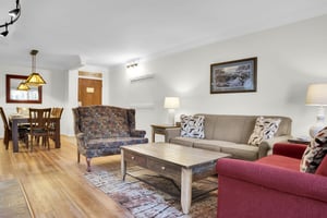 Park Station has a patterned upholstered chair, taupe colored couch, and red love seat in the living room