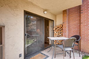 Park Station 113 has a private patio with a table for 2 and a tall stack of cut wood to burn in the wood burning fireplace.