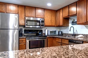 Park Station 133s kitchen has wood cabinets, granite counter tops, and stainless steel appliances.