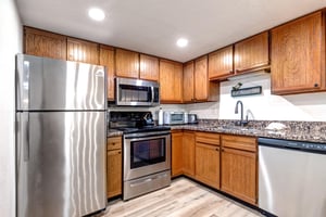 Park Station 133s kitchen has wood cabinets, granite counter tops, stainless steel appliances and recessed lighting.