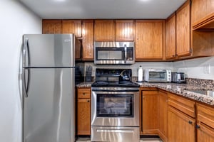 Park Station 133s kitchen has sparkling stainless steel appliances and a toaster over on top of the counter.