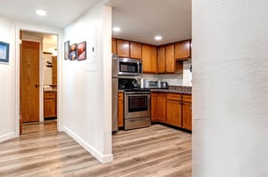 The kitchen sits next to a hallway leading to the main suite.