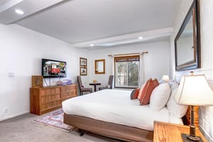 The main suite has a coprner sitting area for two at a small table with a flower vase atop.