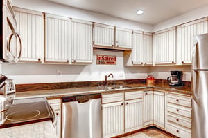 Park Station 134s kitchen with white cabinets, recessed lighting, and stainless steal appliances.