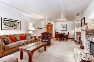 Park Station 134s living room with couch, chair, and coffee table that is open to the dining room.