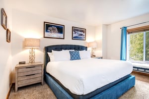 Park Station 139 has a main suite with a kingsize bed with blue suede bedframe and wood furniture.