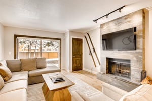 Living room space opens to the sliding glass door to patio, cozy wood burning fireplace and large screen TV