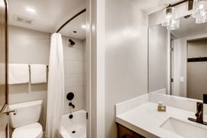 Full guest bathroom with shower tub combo and bullicante vanity lights