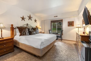 Park Station 214 has a main suite with a king size bed, stair décor on the walls, leather pillows, and solid wood bedframe.