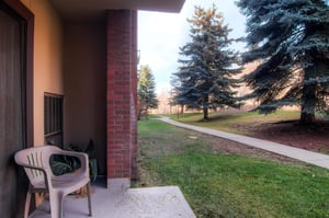 Park Station 121s private patio a chair and lovely trees beyond.