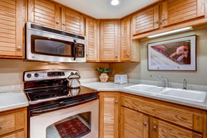 The wellequipped kitchen offers stainless steel appliances and wood cabinets.