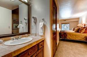 The en suite bathroom has a single sink vanity.