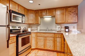 The wellequipped kitchen offers stainless steel appliances and wood cabinets.