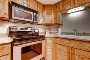 The wellequipped kitchen offers stainless steel appliances and wood cabinets.