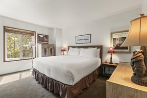 The main suite has a king size bed and wooden furniture.