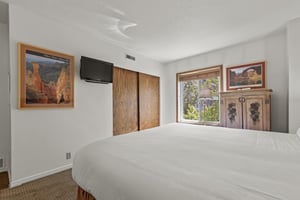 The main suite has a king size bed and wooden furniture.