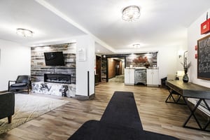 Building 1 lobby entrance with marble and barnwood fireplace, hardwood floors, fireplace mounted TV