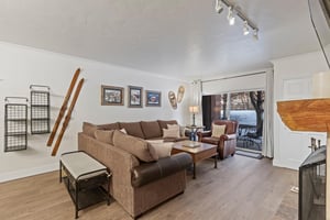 The living room has a large sectional sofa and sliding glass doors leading to a private patio.