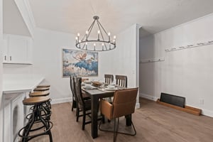 The dining table has 6 chairs, beautiful chandelier and moose artwork.