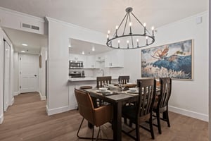 The dining table has 6 chairs, beautiful chandelier and moose artwork.