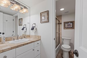 The shared bathroom offers a single sink vanity and bathtub and shower combination.